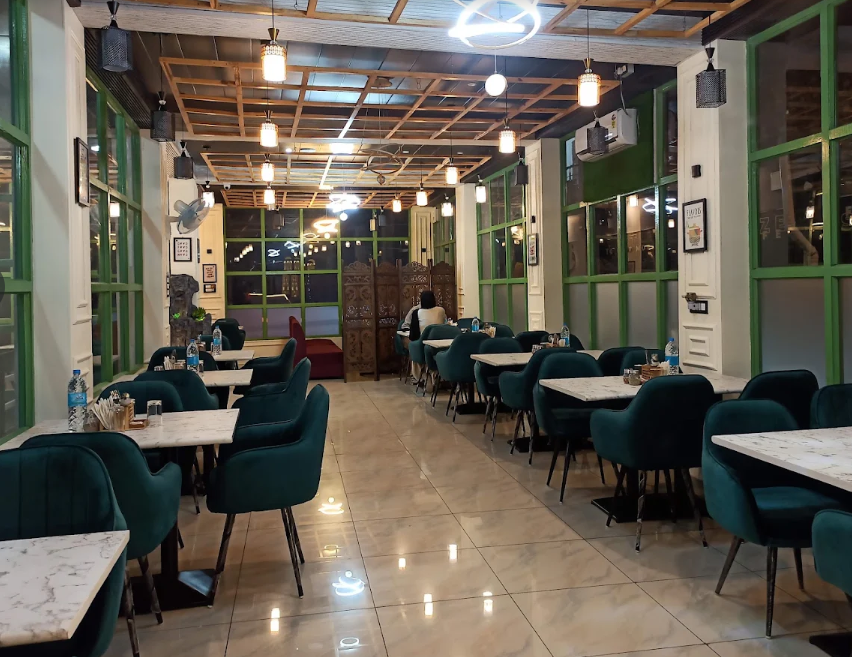 Hunger Station dining room with green chairs and marble tables